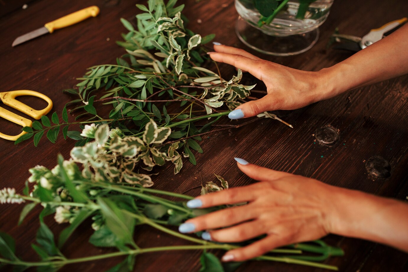 woman-s-hand-sorting-plants-wooden-desk_23-2147882030